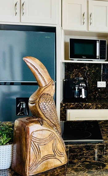 Ein aus Holz geschnitzter Tucán auf der Kücheninsel stehend