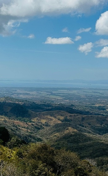 weiter Blick über hüglige Landschaft bis zur Küste Nikoja - Costa Rica
