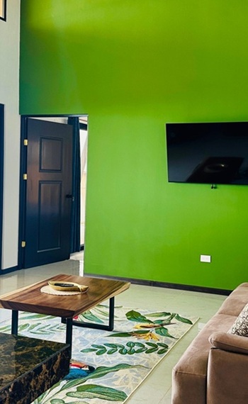 Wohnbereich mit SMART-TV an der Wand und großen Terrassenfenstern